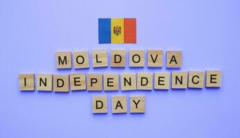 August 27, Moldova Independence Day, flag of Moldova, minimalistic banner with the inscription in wooden letters on a blue background photo