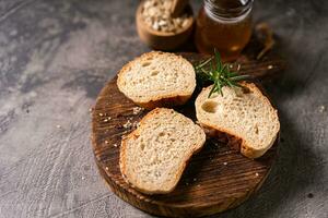 Artisan bread whole wheat baguette white milk and honey on rustic wooden board and abstract table. Sourdough bread photo