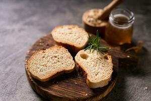 Artisan bread whole wheat baguette white milk and honey on rustic wooden board and abstract table. Sourdough bread photo