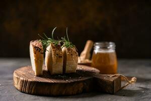 Artisan bread whole wheat baguette white milk and honey on rustic wooden board and abstract table. Sourdough bread photo