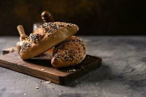 Fresh homemade bread whole wheat baguette on napkin and abstract table. Sourdough bread photo