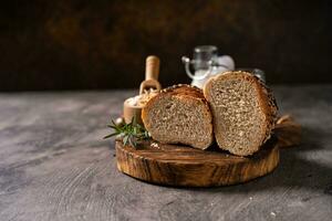 Artisan bread whole wheat baguette white milk and honey on rustic wooden board and abstract table. Sourdough bread photo