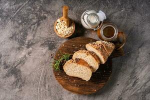 Artisan bread whole wheat baguette white milk and honey on rustic wooden board and abstract table. Sourdough bread photo