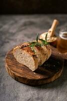 Artisan bread whole wheat baguette white milk and honey on rustic wooden board and abstract table. Sourdough bread photo