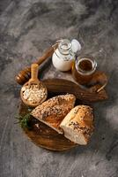 Artisan bread whole wheat baguette white milk and honey on rustic wooden board and abstract table. Sourdough bread photo