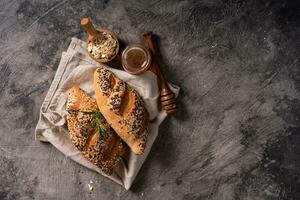 Fresh homemade bread whole wheat baguette on napkin and abstract table. Sourdough bread photo