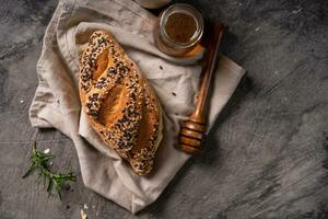 Fresh homemade bread whole wheat baguette on napkin and abstract table. Sourdough bread photo