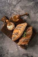 Fresh homemade bread whole wheat baguette on napkin and abstract table. Sourdough bread photo