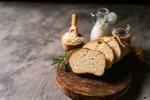 Artisan bread whole wheat baguette white milk and honey on rustic wooden board and abstract table. Sourdough bread photo