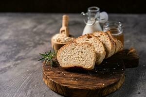 Artisan bread whole wheat baguette white milk and honey on rustic wooden board and abstract table. Sourdough bread photo