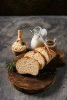 Artisan bread whole wheat baguette white milk and honey on rustic wooden board and abstract table. Sourdough bread photo