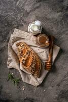 Fresh homemade bread whole wheat baguette on napkin and abstract table. Sourdough bread photo