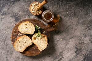 Artisan bread whole wheat baguette white milk and honey on rustic wooden board and abstract table. Sourdough bread photo