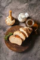 Artisan bread whole wheat baguette white milk and honey on rustic wooden board and abstract table. Sourdough bread photo