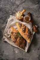 Fresh homemade bread whole wheat baguette on napkin and abstract table. Sourdough bread photo