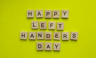 August 13, International Day of Lefties, Lefthanders Day, minimalist banner with the inscription in wooden letters on a yellow background photo