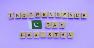agosto 14, independencia día de Pakistán, minimalista bandera con de madera letras, bandera de Pakistán foto