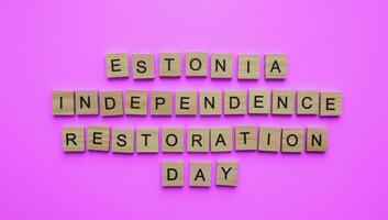 August 20, Estonia Independence Restoration Day, minimalistic banner with the inscription in wooden letters on a pink background photo