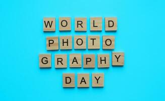 August 19, World Photography Day, minimalistic banner with the inscription in wooden letters on a blue background photo