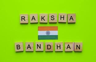 agosto 30, raksha bandhan, bandera de India, minimalista bandera con el inscripción en de madera letras en un verde antecedentes foto