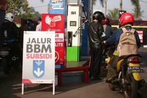 Magelang,Indonesia.July 25, 2023-Motorcycles queue to refuel at a gas station. photo