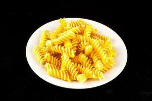 a plate of pasta on a black background photo