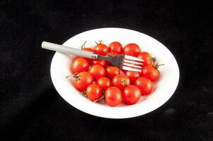 a fork and a bowl of tomatoes photo