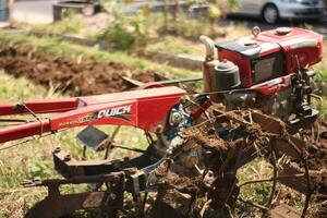 Magelang Indonesia.07302023-a farmer is plowing a field with a modern tool in the form of a tractor. photo