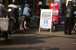 Magelang,Indonesia.July 25, 2023-Motorcycles queue to refuel at a gas station. photo