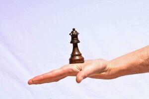 a hand holding a chess piece photo