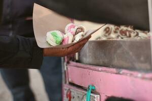 Male hand holding paper bag full of getuk in traditional market. Getuk is a typical Magelang food made from cassava photo