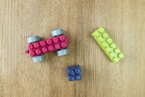 Top view of plastic building blocks on wooden background photo