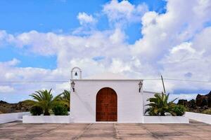 a white church with palm trees and a blue sky photo