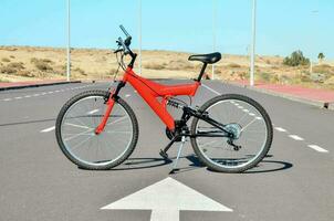 un rojo bicicleta es estacionado en el la carretera foto