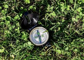 a compass is laying on the grass photo