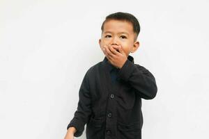 A smiling toddler boy closing his mouth while looks at the camera with confidence, isolated on white background photo