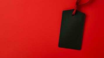 Black empty price tag on red background. Black Friday concept, template copyspace photo