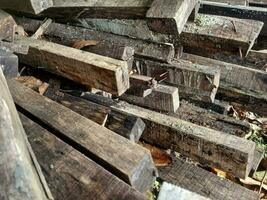 pile of used building wood that is no longer in use. there are still nails stuck so that it looks natural photo