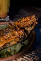 Tasty grilled fish on kitchen table photo