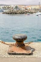 a rusty anchor on the shore of a harbor photo