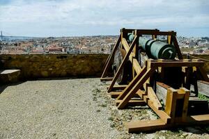 a cannon on top of a stone wall overlooking a city photo