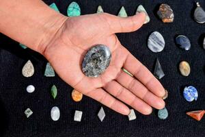 a person holding a stone in front of other stones photo