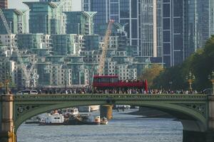 multitud caminando por excursión autobús en Westminster puente con edificio en antecedentes foto