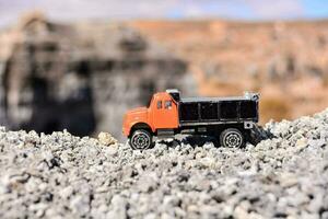 a toy truck is sitting on top of a pile of rocks photo