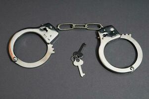 handcuffs and keys on a gray surface photo