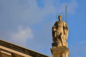 statue of person on the roof of the cathedral photo