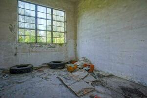 un abandonado habitación con un ventana y llantas foto