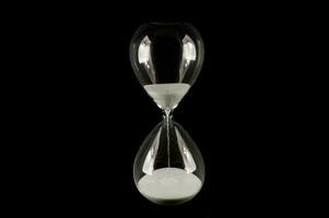 an hourglass with sand on a black background photo