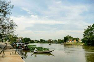 a river with boats and trees on the shore photo