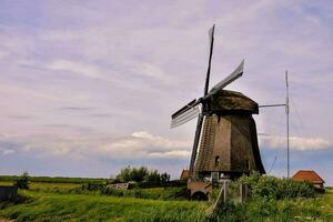 a windmill in the middle of a field photo